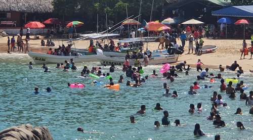 Turistas disfrutan de la playa Puerto Angelito, en el municipio de San Pedro Mixtepec, Oaxaca. Se espera una ocupación hotelera de 70 por ciento en las playas de la entidad entre viernes y sábado.