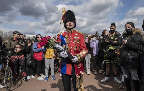  Pese a que la familia real pidió a los súbditos no depositar flores en sus residencias, decenas de personas se reunieron a las afueras del Palacio de Buckingham, en Londres. Foto Ap