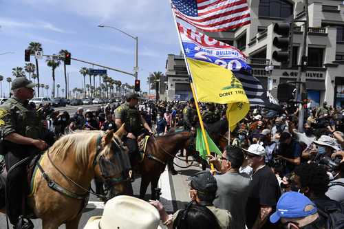 Vigilancia policial durante la manifestación del llamado movimiento “Las vidas blancas importan” que se celebró ayer en Huntington Beach, California. La marcha fue organizada por grupos de ultraderecha.
