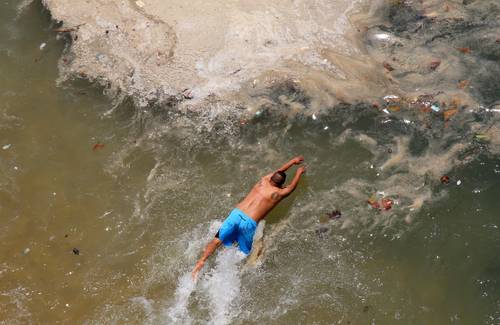 Turistas nadan en aguas sucias de la playa La Langosta, en Acapulco, este viernes, en las que incluso se puede ver basura. La Secretaría de Turismo municipal estimó que alrededor de 248 mil paseantes visitaron el puerto durante el periodo vacacional de Semana Santa, a pesar de la emergencia sanitaria por el Covid-19.