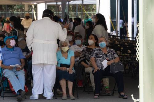 Personas mayores escuchan las instrucciones de un médico en el área de observación tras recibir la vacuna contra el virus del Covid-19 en el Campo Marte.