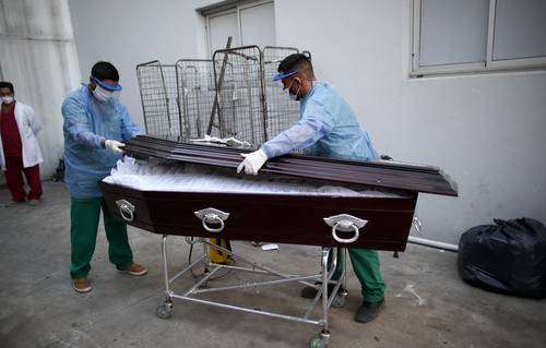 Trabajadores del hospital Doctor Norberto Raúl Piacentini, en Lomas de Zamora, Argentina, alistan el ataúd de un paciente que falleció a causa del Covid-19.