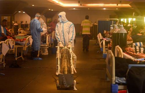  Imagen de la tragedia en India. Trabajadores de salud atienden a pacientes en un salón de banquetes de Nueva Delhi, convertido temporalmente en centro de cuidados. Foto Afp