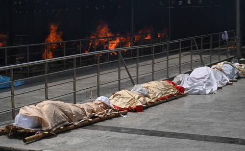  Imagen de la tragedia en India. Cuerpos de víctimas del Covid-19 esperan para ser cremados, en la misma ciudad, donde ya se reporta escasez de combustible. Foto Afp