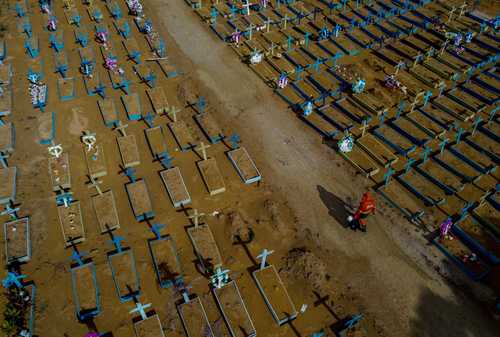 Ayer, Brasil superó la cifra de 400 mil muertes por Covid-19. En la imagen, un sepulturero camina entre tumbas de víctimas del virus en el cementerio de Nuestra Señora Aparecida, en Manaos, estado de Amazonas.