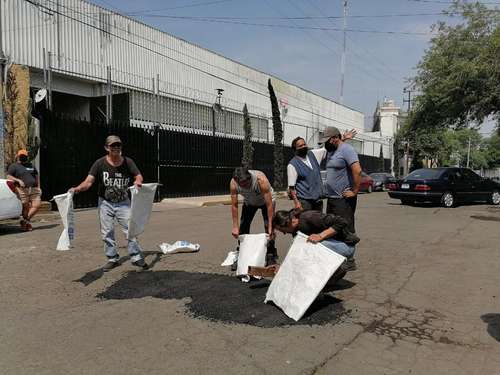 Con recursos propios y de manera rústica, vecinos de la calle Vainilla, en la colonia Granjas México, en Iztacalco, repararon algunos de los más de 400 baches que tiene ésta.