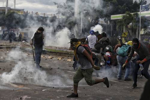 Enfrentamientos de manifestantes con elementos policiacos ayer en la ciudad de Cali, pese a que el presidente Iván Duque retiró su polémica propuesta fiscal.