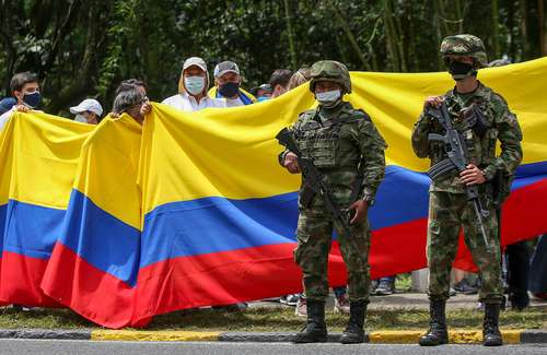 Manifestación en Cali, vigilada por efectivos militares. La mayor cifra de decesos, según el Ministerio de Defensa, se han dado en esta ciudad.