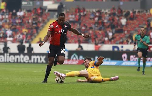 El rojinegro Renato Ibarra recibe la barrida de André-Pierre Gignac en la disputa por el balón durante el duelo de ayer en el estadio Jalisco.