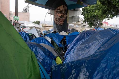 En El Chaparral, cruce fronterizo en Tijuana, migrantes improvisaron un campamento en espera de que autoridades de Estados Unidos respondan a solicitudes de asilo.