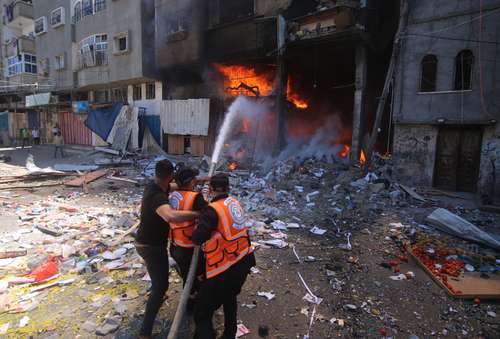 Bomberos palestinos combaten el fuego provocado por un ataque aéreo israelí en una casa, en la ciudad de Rafá, en el sur de la franja de Gaza.