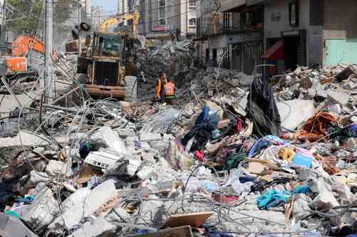 Una excavadora limpia escombros en el distrito residencial Rimal de la ciudad de Gaza ayer, luego del bombardeo masivo israelí en el enclave controlado por Hamas. Los ataques israelíes mataron a 40 palestinos en la franja de Gaza, la peor cifra diaria de muertos en casi una semana.