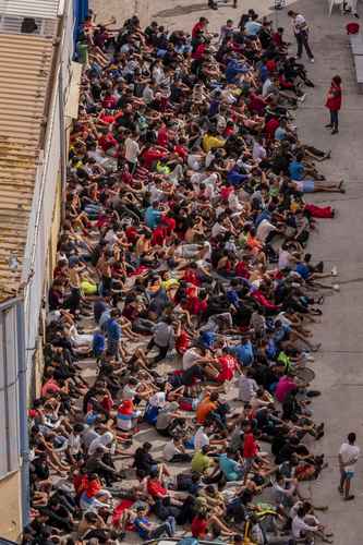 Menores migrantes no acompañados que el lunes lograron ingresar al enclave español de Ceuta, en la zona fronteriza con Marruecos, esperan en un almacén utilizado como refugio temporal a que se les aplique una prueba de Covid-19.