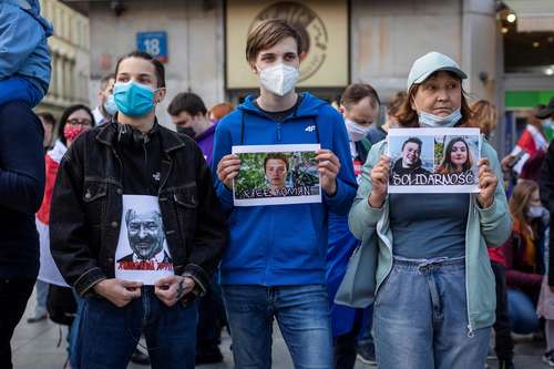  Bielorrusos que viven en Polonia se manifestaron afuera de las oficinas de la Comisión Europea, en Varsovia, para exigir la liberación del joven bloguero y su novia Sofia Sapega. Llevan carteles con fotos del presidente Aleksandr Lukashenko y la pareja arrestada. Foto Afp