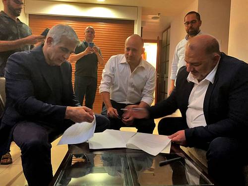 De izquierda a derecha: los líderes partidistas Yair Lapid, del centrista Yesh Atid; Naftali Bennett, de la derechista Yamina, y Raam Mansour Abbas, de la conservadora Liga Árabe Unida, firman el acuerdo de gobierno de unidad, ayer en la ciudad de Ramat Gan.