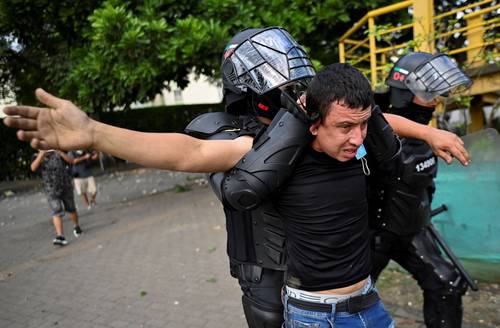 Un manifestante es detenido por la policía antidisturbios en Cali.