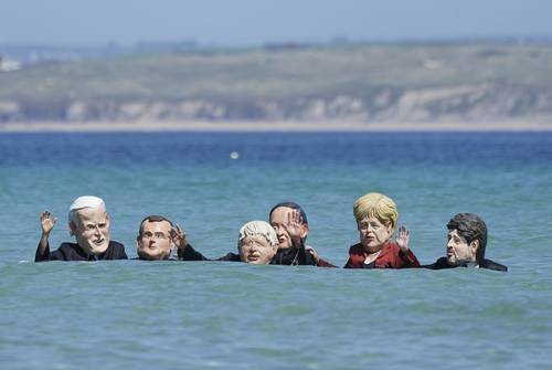 Activistas protestaron ayer en Cornwall con máscaras de los líderes de EU, Joe Biden; Francia, Emmanuel Macron; GB, Boris Johnson; Japón, Yoshihide Suga; Alemania, Angela Merkel, y de Canadá, Justin Trudeau .