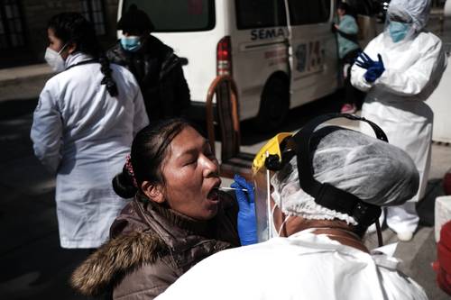 Una trabajadora de la salud de Bolivia toma una muestra a una ciudadana para la prueba de reacción en cadena de la polimerasa (PCR), ayer en La Paz.