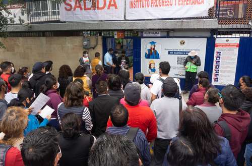 Padres de jóvenes que fueron a presentar examen de ingreso a educación media superior aguardan afuera del Instituto Progreso y Esperanza, en la alcaldía Iztapalapa.