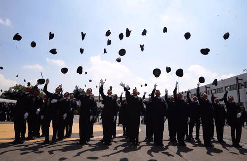 Cadetes de la generación 277 de la Universidad de la Policía de la Ciudad de México arrojaron sus gorras tras la ceremonia de graduación.