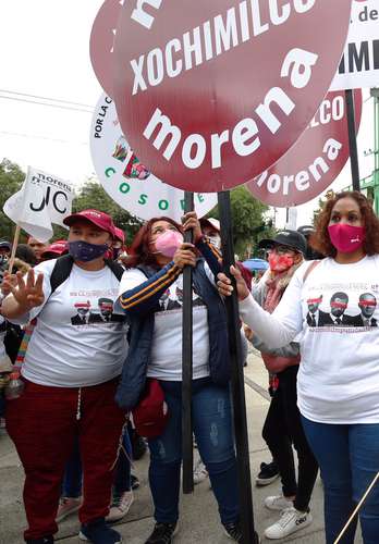 Afiliados de Morena portan playeras sobre la jornada de respaldo a la consulta ciudadana en el Monumento a Lázaro Cárdenas, en la Ciudad de México.