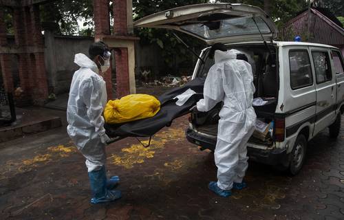 Trabajadores transportan un cadáver para ser cremado en Gauhati, India, país que ayer se convirtió en el tercero con más de 400 mil muertos.