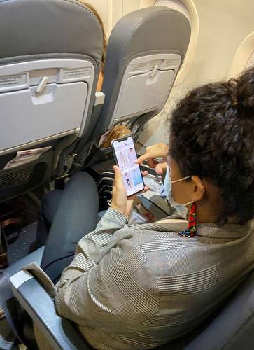 La secretaria del Trabajo, Luisa María Alcalde, observa ropa y moda en su teléfono celular, al regreso de la gira del presidente Andrés Manuel López Obrador en el vuelo Hermosillo-Ciudad de México, el pasado domingo 27 de junio.