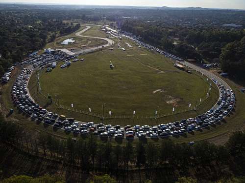 Personas hacen fila en el centro de auto-vacunación instalado en el autódromo Rubén Dumot, en Capiata, Paraguay, para recibir una dosis del biológico de Pfizer.