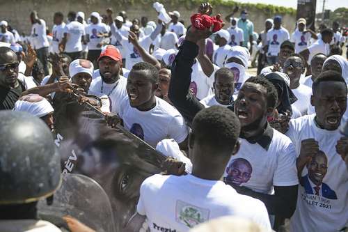 Guardias bloquean el paso de seguidores al funeral del asesinado presidente haitiano Jovenel Moïse.