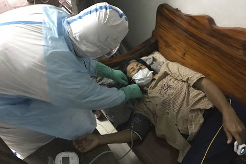 Un voluntario del grupo “Saimai Sobrevivirá” –que provee equipo médico– ajusta el suministro de oxígeno en la casa de una mujer infectada por el Covid-19. El sistema hospitalario de Tailandia ha sido rebasado ante un nuevo incremento de contagios, por lo que gente común brinda suministros y cuidados, arriesgando su propia salud.