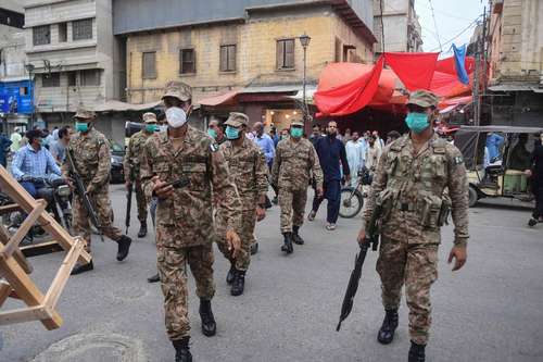 Soldados paquistaníes llegan a un mercado para hacer cumplir el confinamiento nocturno ante un incremento de casos de Covid-19 en Karachi.