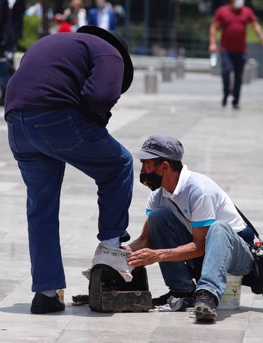 Tras el largo confinamiento por la pandemia de Covid-19, trabajadores no asalariados salieron a las calles para reactivar su economía. En esta imagen, un aseador de calzado en la zona centro de la Ciudad de México