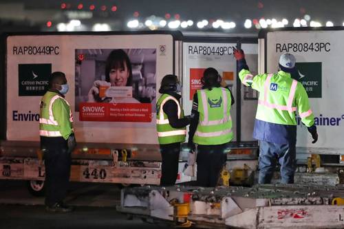 Trabajadores del Aeropuerto Internacional de la Ciudad de México reciben el cargamento del laboratorio Sinovac que llegó la madrugada de ayer.