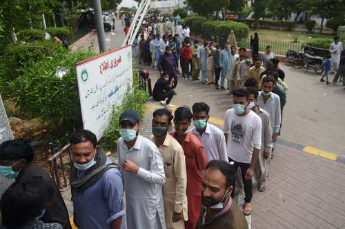 Personas formadas esperan ser inoculadas en un centro de vacunación en Karachi, Pakistán.