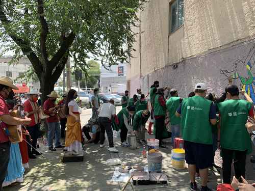 Beneficiarios de programas de reinserción social del Instituto de la Juventud capitalino pintan un mural en la colonia Doctores.