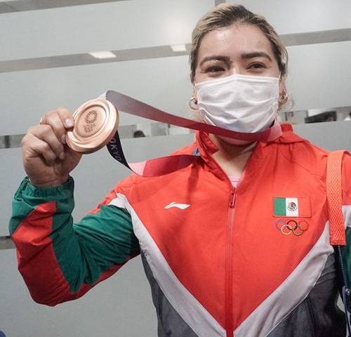 La pesista chiapaneca muestra orgullosa su bronce al llegar al aeropuerto de la CDMX.