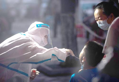 Un trabajador médico toma una muestra de un residente para una prueba de ácido nucleico de Covid-19, en Wuhan, en la provincia de Hubei, en el centro de China.