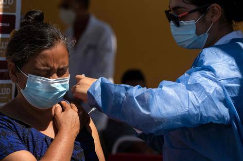 Una de los cientos de solicitantes de asilo que acampan en el cruce fronterizo de El Chaparral, en Tijuana, Baja California, es vacunada contra el Covid-19.
