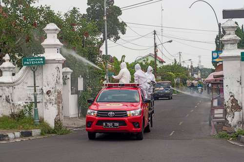 En Yogyakarta, Indonesia, trabajadores rocían desinfectante en las calles como medida preventiva frente al Covid-19.
