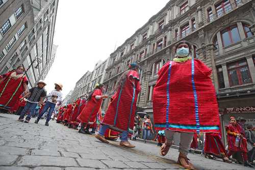 Integrantes de comunidades originarias marchan en calles del Centro Histórico para festejar el Día Internacional de los Pueblos Indígenas, no obstante que las autoridades de salud anunciaron que el semáforo epidemiológico regresaba esta semana al rojo para la Ciudad de México.