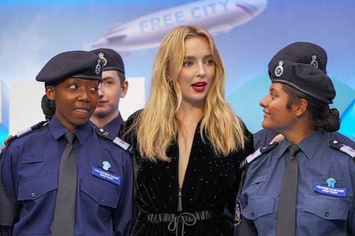 Jodie Comer, al centro, posa con cadetes de la policía metropolitana a su arribo al estreno de la película en Londres.