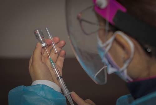 Las empresas chinas en AL se han diversificado, pues cada vez más abarcan el sector salud. En la imagen, un médico en Ecuador prepara una vacuna Sinovac para aplicarla.