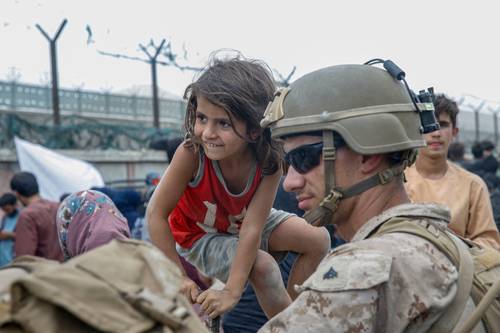 Un marine estadunidense resguarda a una niña durante una evacuación en el aeropuerto internacional Hamid Karzai, en Kabul.