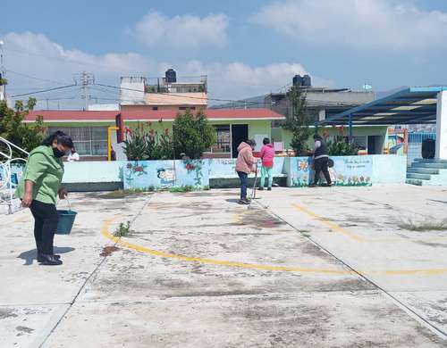 Padres de alumnos realizaron labores de limpieza en la primaria Benito Juárez, en el municipio de Ecatepec, estado de México. El regreso a clases presenciales será voluntario en la entidad mexiquense.