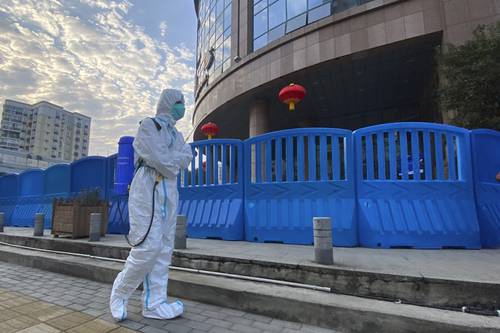 Imagen de febrero de 2021 en la que un trabajador camina fuera del Hospital Central de Wuhan, China, donde se dio la alarma en los primeros días de la pandemia. Este viernes se publicó que las agencias de inteligencia estadunidenses siguen divididas sobre los orígenes del Covid-19.