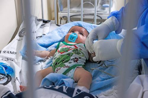 En la ciudad de Idlib, controlada por rebeldes, un médico atiende a un bebé en la recién abierta sala de aislamiento, una iniciativa de la ONG Sociedad Médica Siria-estadunidense, en medio de un incremento de casos de Covid-19 entre niños pequeños.