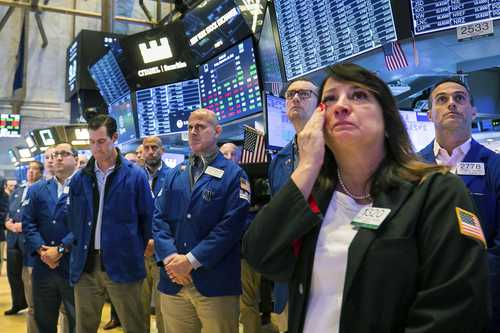 Operadores se reúnen para guardar un minuto de silencio en el piso de remates de la Bolsa de Nueva York la víspera del 11 de septiembre.