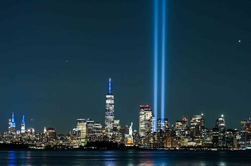 La estatua de la Libertad brilla cerca del tributo de luz, como parte de la conmemoración por el 20 aniversario de los ataques terroristas en la ciudad de Nueva York.