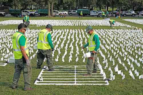 En Washington, Suzanne Brennan realiza una instalación artística con 630 mil banderas blancas en memoria de los estadunidenses que han muerto por Covid-19.