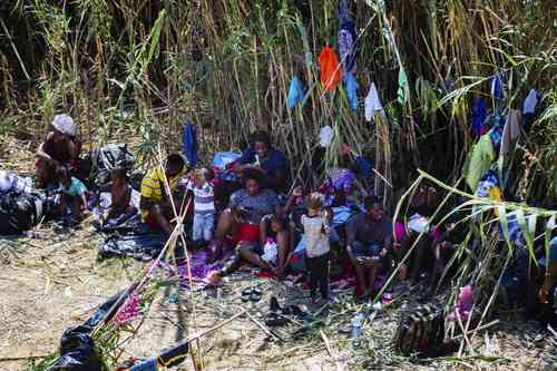 Migrantes haitianos descansan junto al puente internacional de Del Río, Texas.
